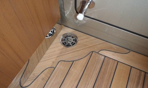 Photo of teak floor and corner drain, on a boat
